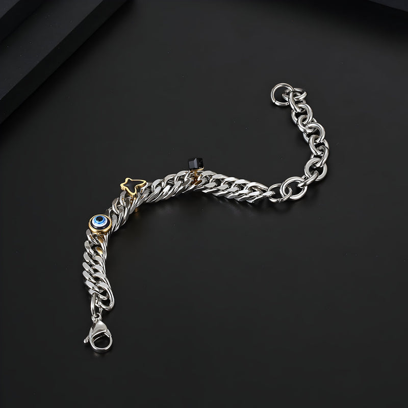 Bracelet en titane argenté à maillons larges avec charms oeil bleu et papillon doré, fermoir robuste.