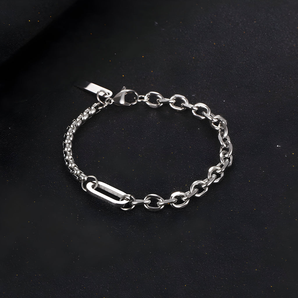 Bracelet homme en titane argenté à double maille robuste avec fermoir sécurisé sur fond noir.