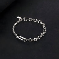 Bracelet homme en titane argenté à double maille robuste avec fermoir sécurisé sur fond noir.