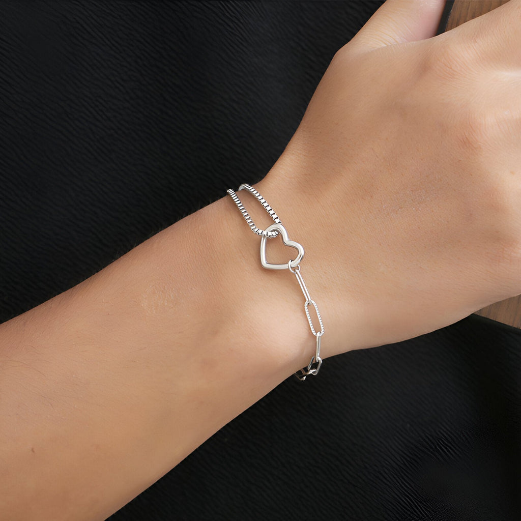 Bracelet mixte en titane argenté avec double maille fine et charm cœur ajouré.