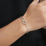 Bracelet mixte en titane argenté avec double maille fine et charm cœur ajouré.