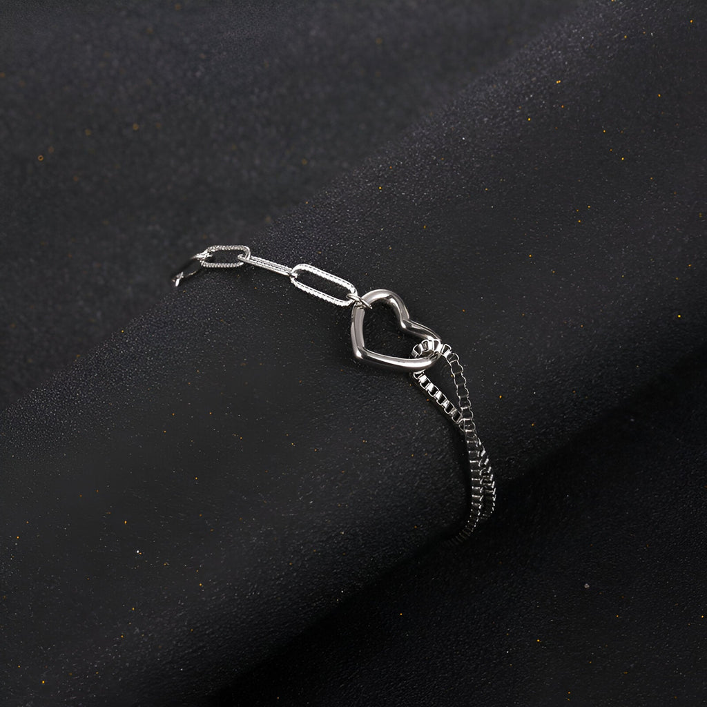 Bracelet en titane argenté avec double maille et charm cœur ajouré, design mixte.