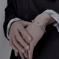 Bracelet homme en titane argenté double maille avec croix scintillante sur poignet.