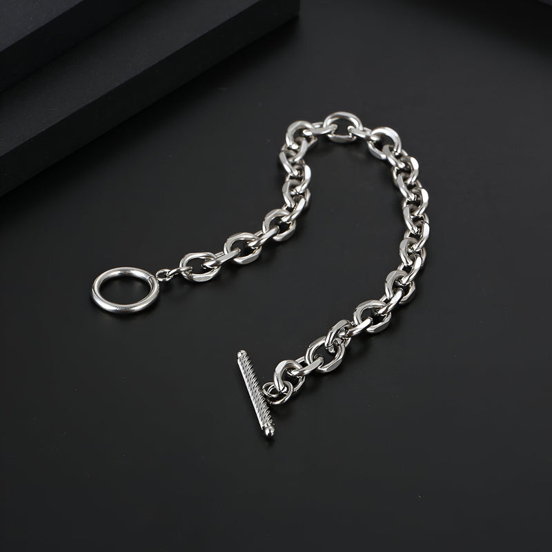 Bracelet homme en titane argenté à maillons ovales avec fermoir en T classique sur fond noir.