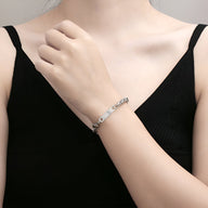 Bracelet gourmette en titane argenté maille spiga, finition brillante, modèle Swann, porté au poignet.