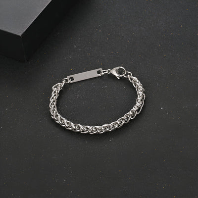 Bracelet gourmette mixte en titane couleur argent avec maille spiga et plaque gravée rectangulaire.