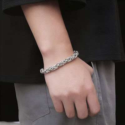 Bracelet homme en titane argenté à maille byzantine, style épais et élégant, porté au poignet.