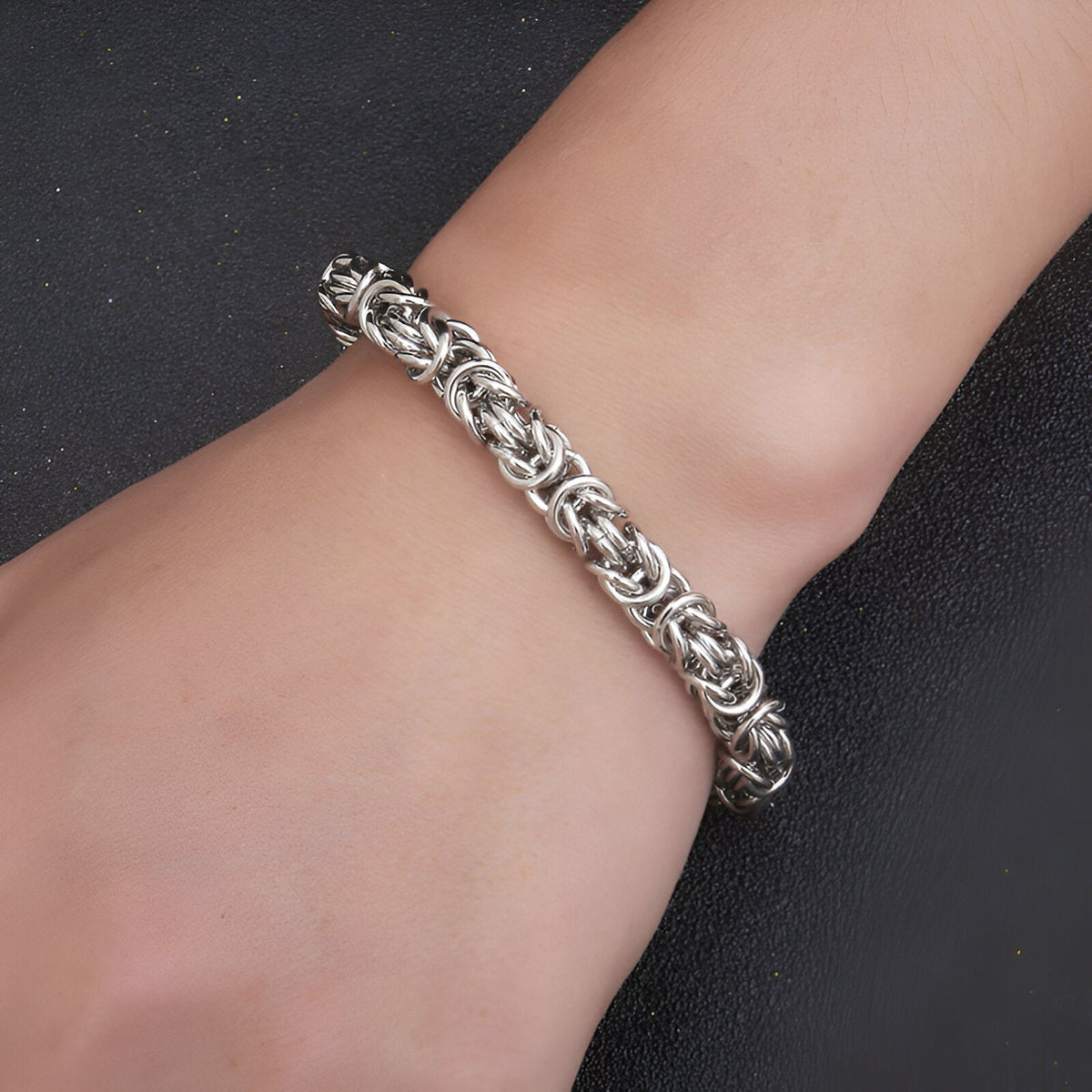 Bracelet en titane maille byzantine argentée, design masculin détaillé, porté au poignet.