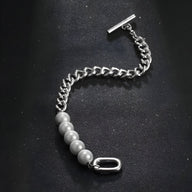 Bracelet homme en titane argenté avec maille cubaine et perles grises distinctives, fermoir barre toggle.