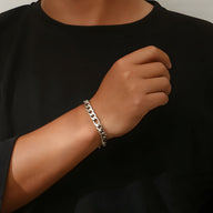 Bracelet homme en titane argenté à maille Figaro sur poignet, style classique et épuré.