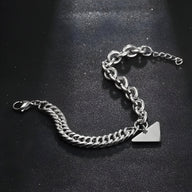 Bracelet homme en titane argenté avec maille forçat et spiga, plaquette triangulaire design.