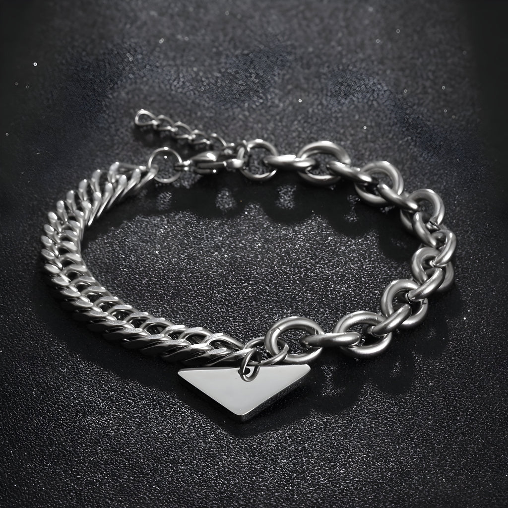Bracelet homme en titane argenté avec maille forçat et spiga, plaquette triangulaire centrale.