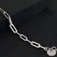 Bracelet homme en titane argenté à maille forçat avec pendentif rond lisse.