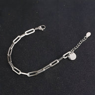 Bracelet homme en titane argenté, maille forçat allongée, fermoir mousqueton, chaîne de réglage avec pendentif rond.