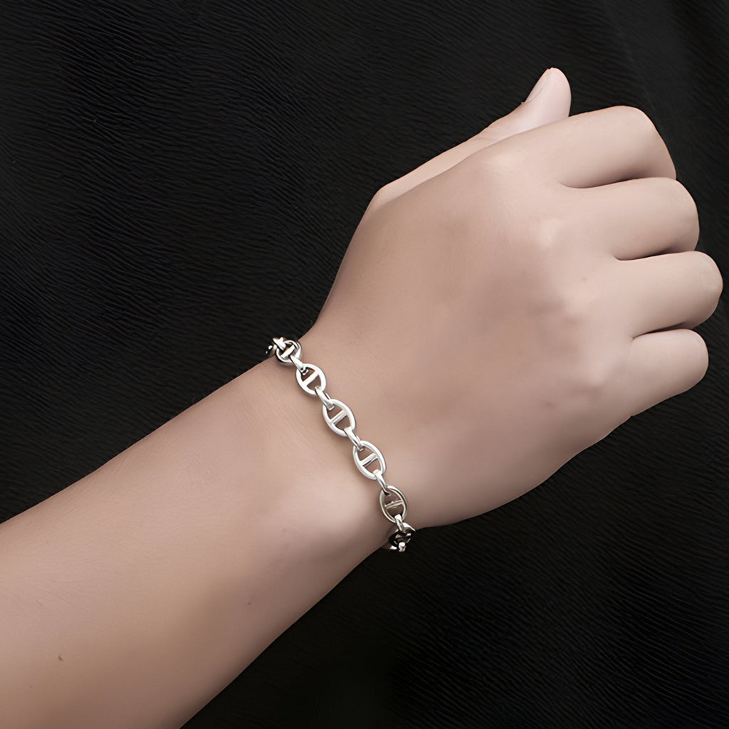 Bracelet en titane argenté à maille marine élégante porté au poignet masculin.
