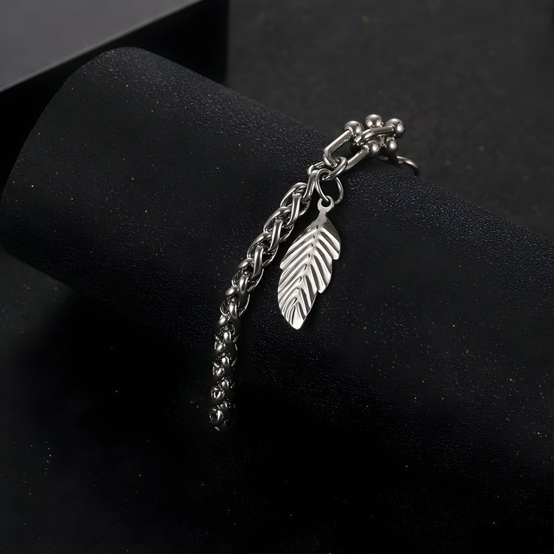 Bracelet en titane argenté avec maille spiga et charm plume pendante fine.