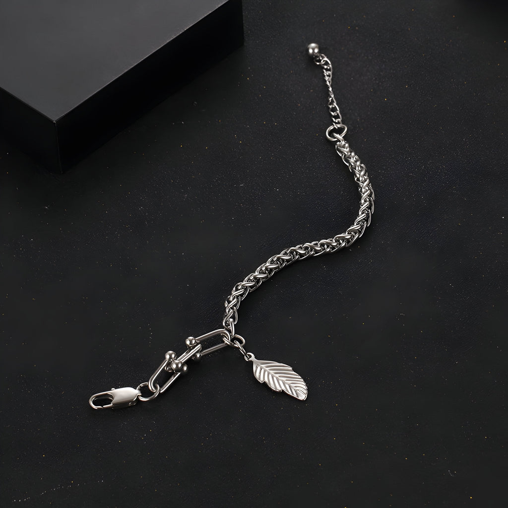 Bracelet en titane argenté maille spiga avec charm plume suspendu, modèle Alissa, pour femme.