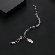 Bracelet en titane argenté maille spiga avec charm plume suspendu, modèle Alissa, pour femme.