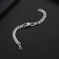 Bracelet homme en titane argenté à maille spiga avec noeud décoratif au centre sur fond noir.