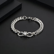 Bracelet homme en titane argenté maille spiga avec noeud central élégant sur fond noir.
