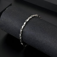 Bracelet homme en titane argenté avec maille torsadée fine et fermoir discret.