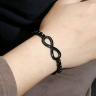 Bracelet en titane noir avec motif infini mat et perles rondes brillantes.