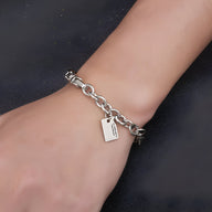 Bracelet en titane argenté avec chaîne maillons ronds et plaque gravée pour homme.