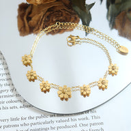 Bracelet en titane plaqué or 18 carats avec fleurs délicates et chaîne fine réglable.