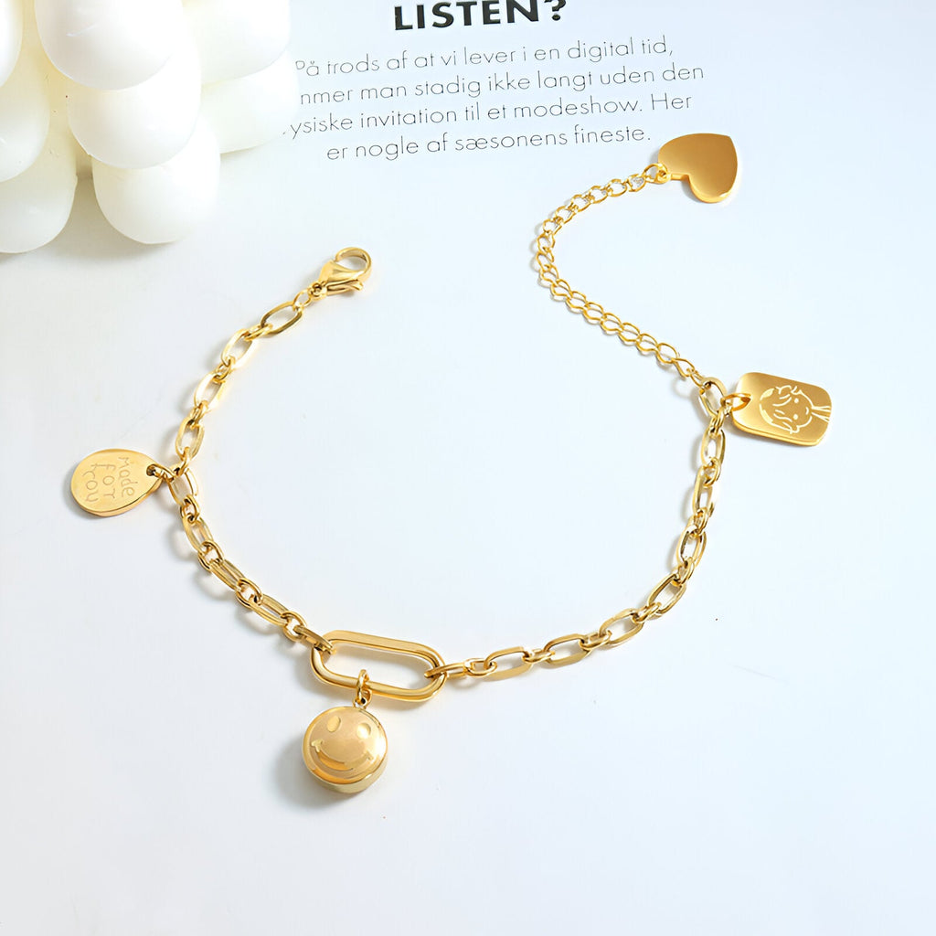 Bracelet or 18 carats en titane avec maillons ovales et médaillons variés, fermoir original en forme de boucle.