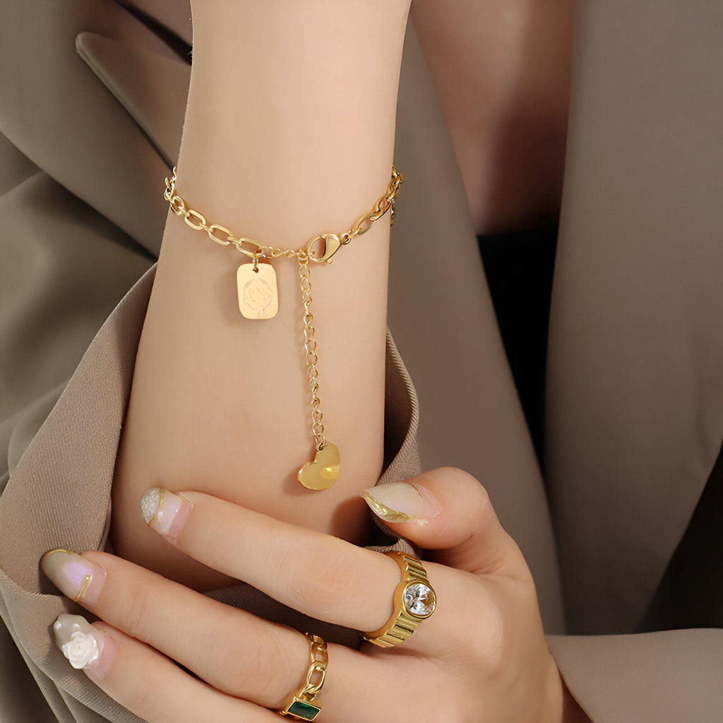 Bracelet en or 18 carats avec médaillons variés et chaîne fine ajustable.