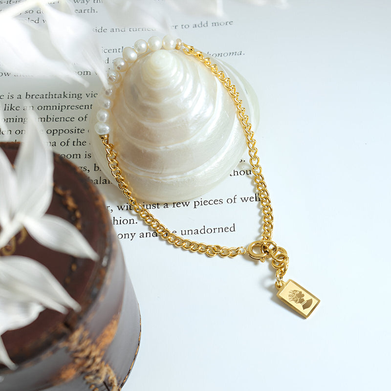 Bracelet fin en titane plaqué or 18 carats avec perles naturelles et pendentif rectangle gravé.