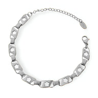 Bracelet en titane argenté avec maillons hexagonaux et étoiles creuses, fermoir mousqueton.