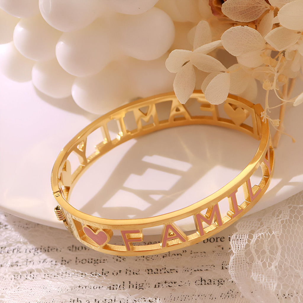 Bracelet rigide en titane plaqué or 18 carats avec découpe mots "Family" style minimaliste.