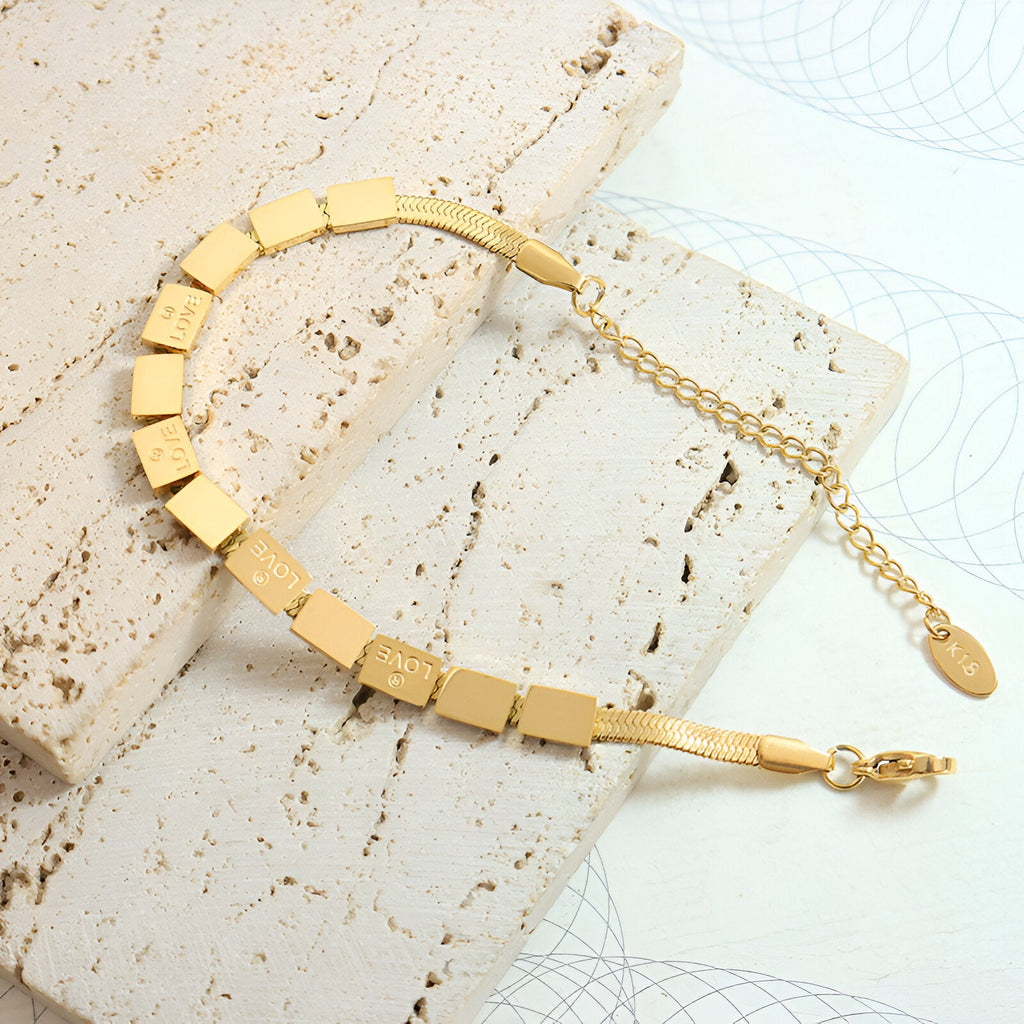 Bracelet en titane plaqué or 18 carats avec maillons carrés texturés et chaîne réglable fine.