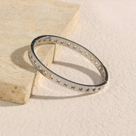 Bracelet en titane argenté avec motif d’étoiles creuses, design élégant et fin, modèle Julie.