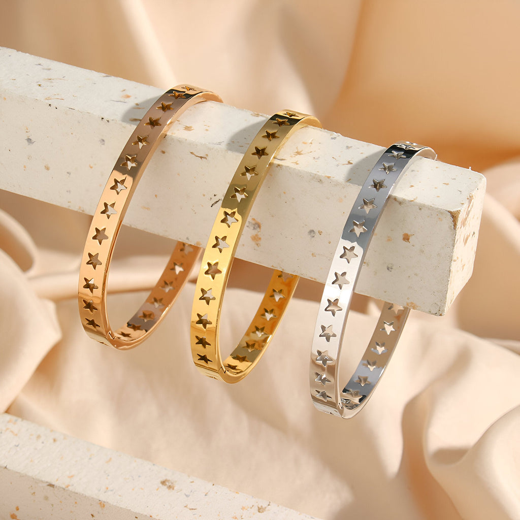 Bracelets rigides en titane plaqué or, or rose et argent avec motif étoiles creuses délicates.