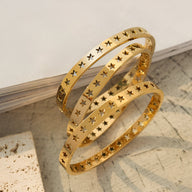 Bracelet en titane plaqué or 18 carats avec motif d'étoiles creuses délicates, modèle fin et élégant.