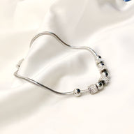 Bracelet en titane argenté avec perles et pierres de cristal brillantes, design élégant et raffiné.