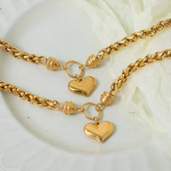 Bracelet en titane plaqué or avec maille torsadée et pendentif cœur lisse et brillant.