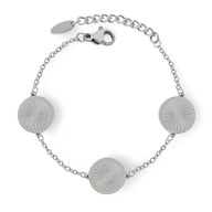 Bracelet en titane argenté avec trois médaillons ronds rayonnants et chaîne fine ajustable.