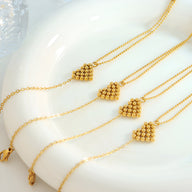 Bracelets en titane plaqué or avec motif cœur perlé sur chaîne fine délicate.