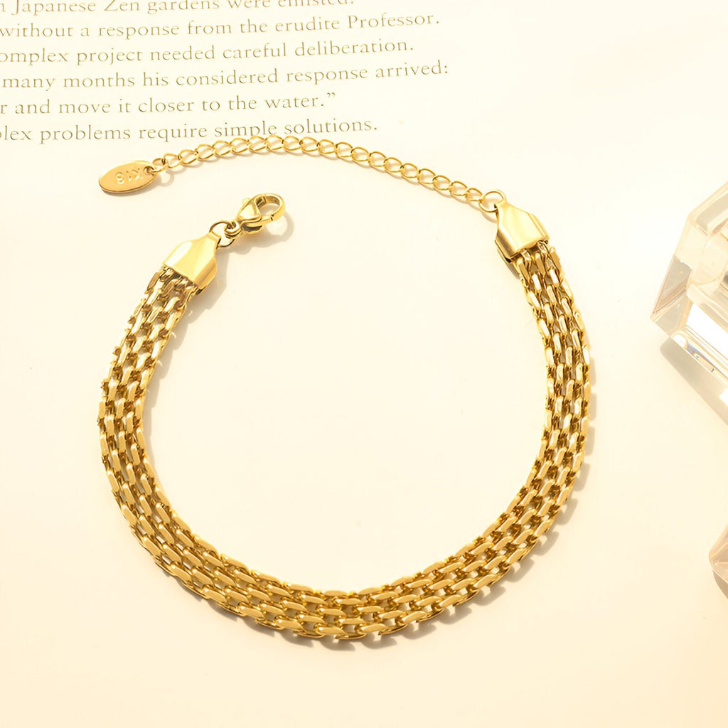 Bracelet en titane plaqué or style montre à maillons tressés avec chaîne ajustable et fermoir mousqueton.