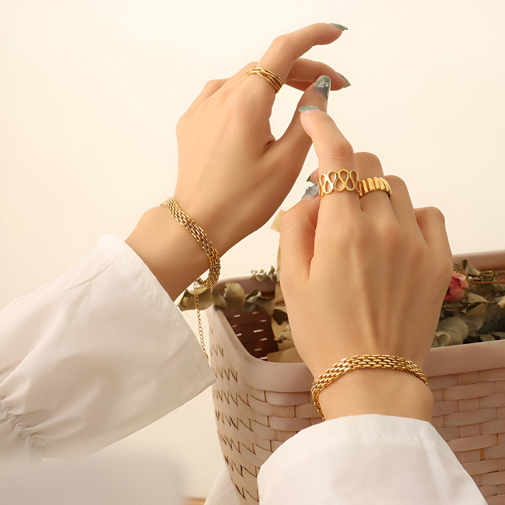 Bracelet en titane plaqué or style montre avec maillons larges porté sur poignet féminin.