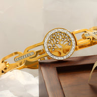 Bracelet en titane doré pour femme avec pendentif arbre de vie orné de petits cristaux blancs.