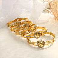 Bracelet en titane doré pour femme avec pendentif arbre de vie et détails en strass.