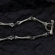 Bracelet en titane argenté avec maillons en forme d'os et fermoir anneau rond.