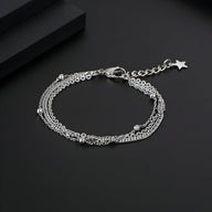 Bracelet triple en titane argenté pour homme avec petites perles et fermoir étoile.