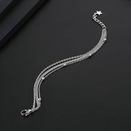 Bracelet homme triple en titane argenté avec chaînes fines et fermoir étoile sécurisé.