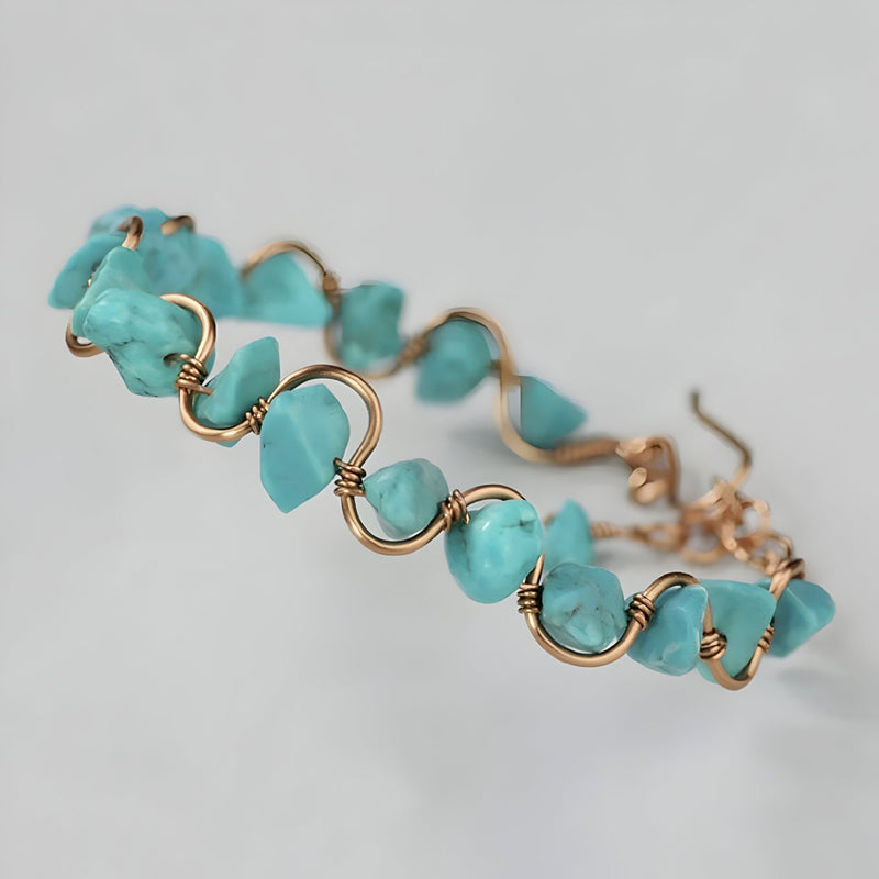 Bracelet femme en cuivre doré avec pierres de turquoise bleue irrégulières enfilées sur fil ondulé.