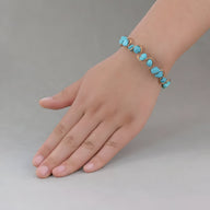 Bracelet pour femme en pierres turquoises bleues ovales montées sur fil cuivre réglable.